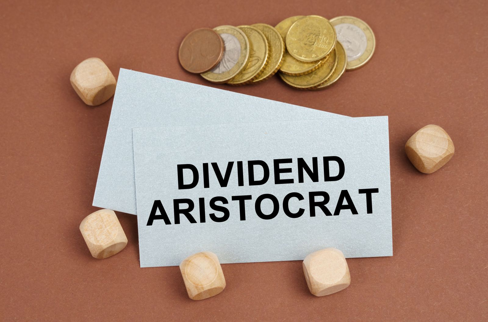 Dividends - coins, cubes and a business card with the inscription - Dividend Aristocrat by SkazovD via Shutterstock